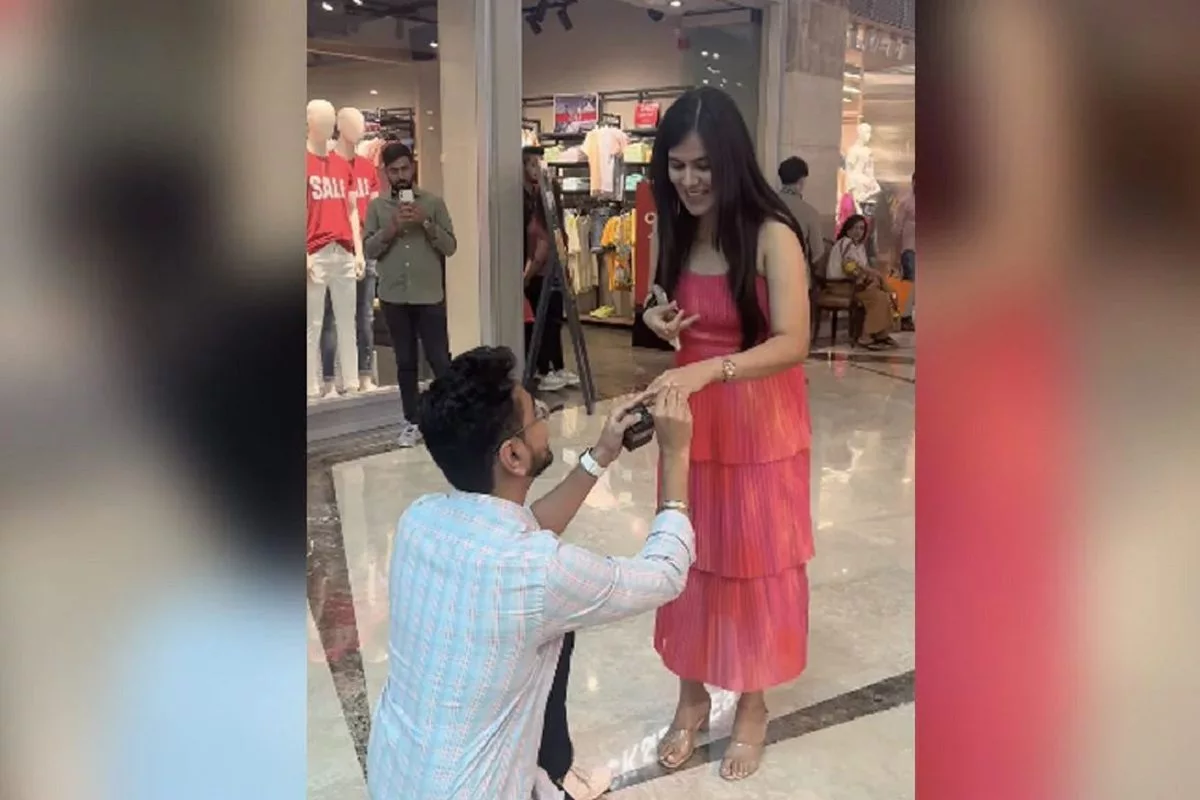 A man proposes to his girlfriend inside a mall