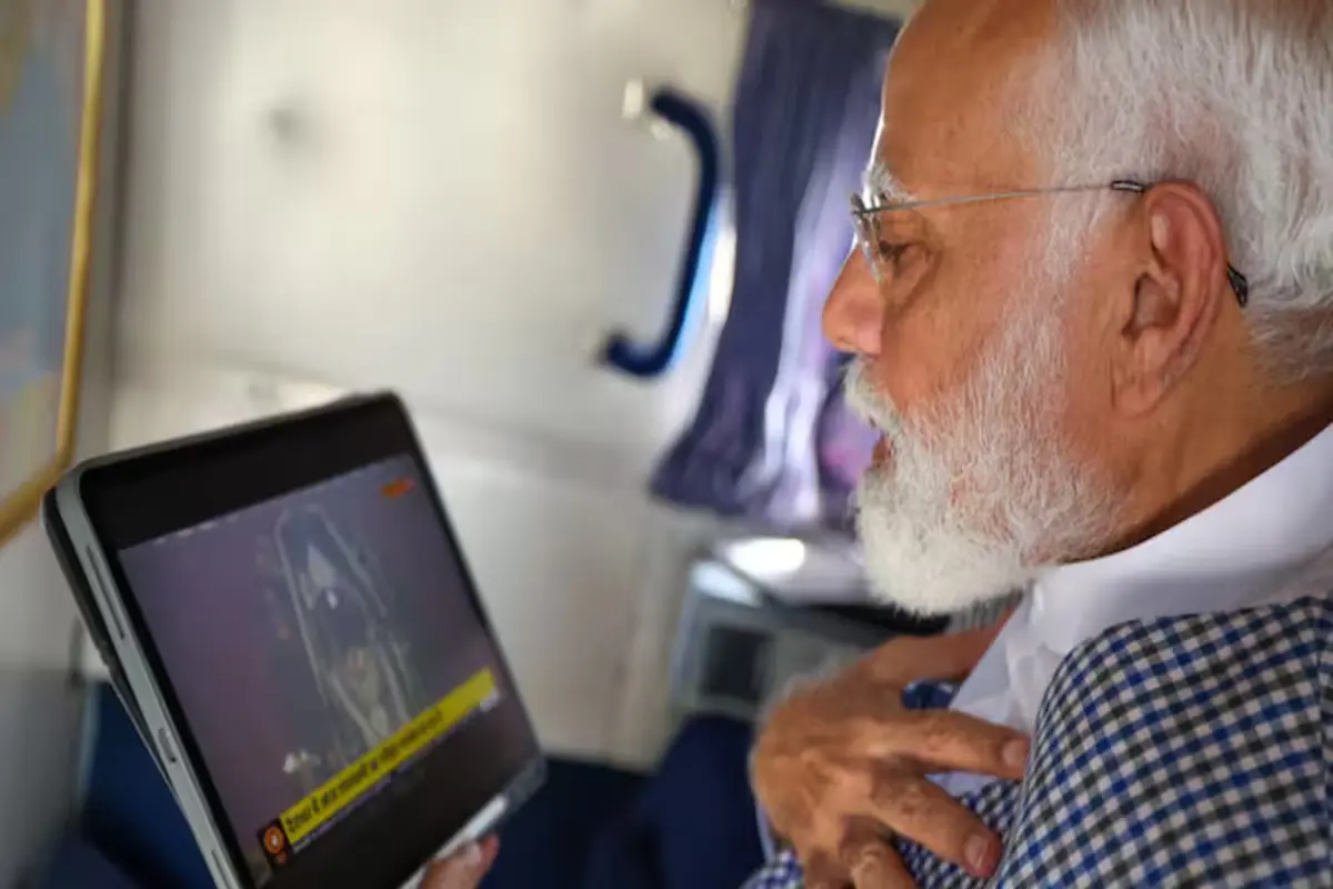 PM Modi watches the Surya Tilak ritual on a tablet.